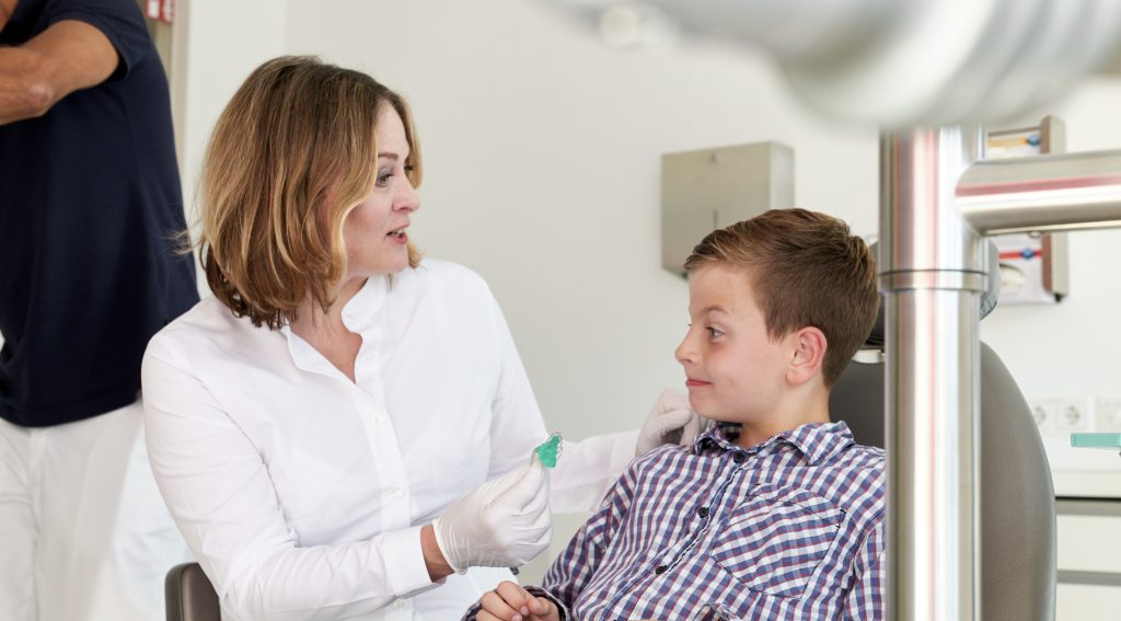 Behandlungssituation mit Kind, Einsetzen einer herausnehmbaren Zahnspange